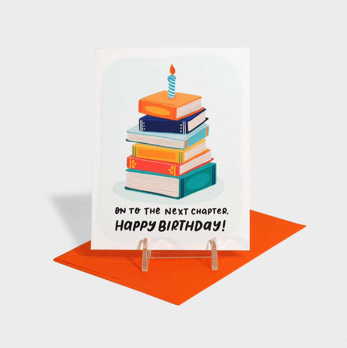 Greeting card with a stack of books with a candle on top.