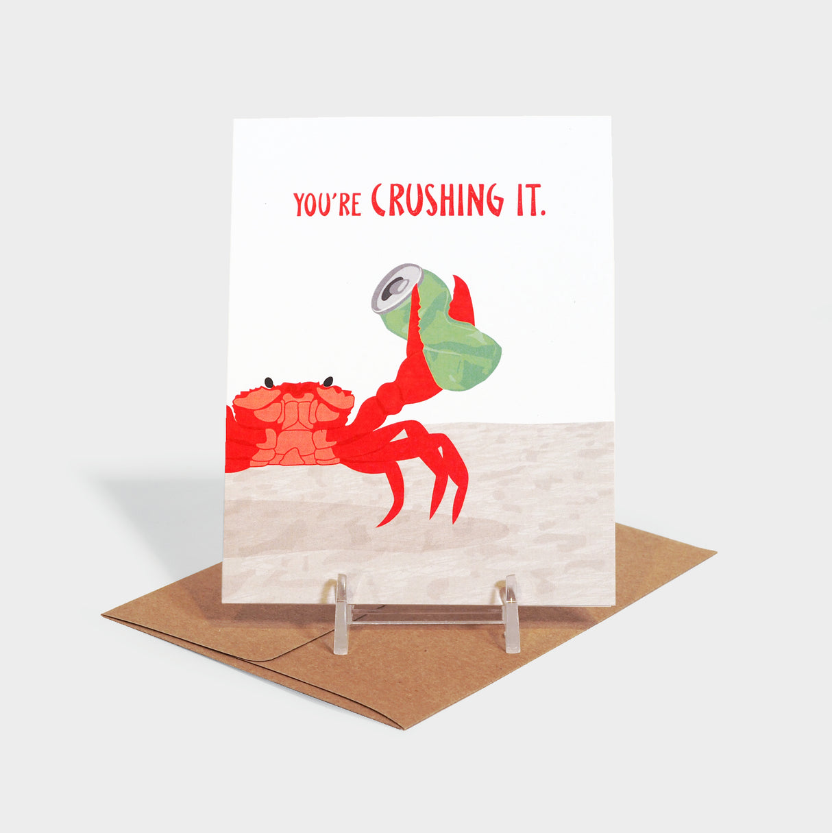 Greeting card with illustration of a crab crushing a can. 