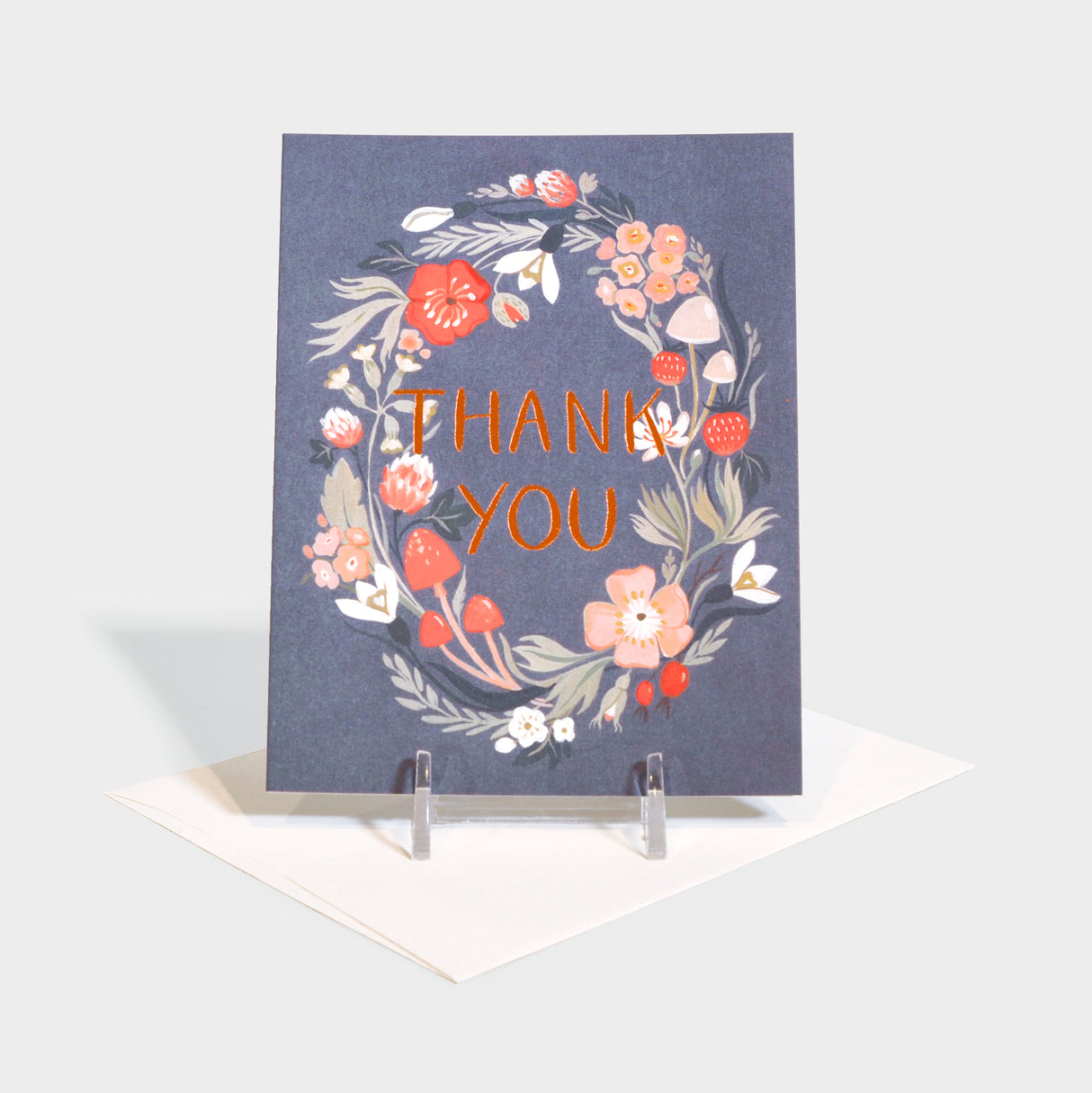 Greeting card with floral wreath imagery surrounding foil-stamped text.