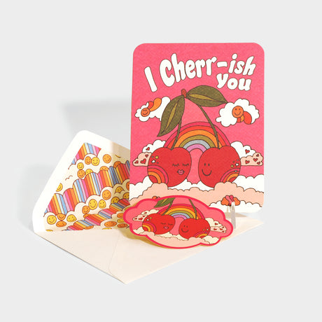 Greeting card with die-cut sticker. Features retro style illustrations of two cherries in the clouds.