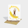 Greeting card with illustration of an orangutan holding a balloon, standing on a banana.