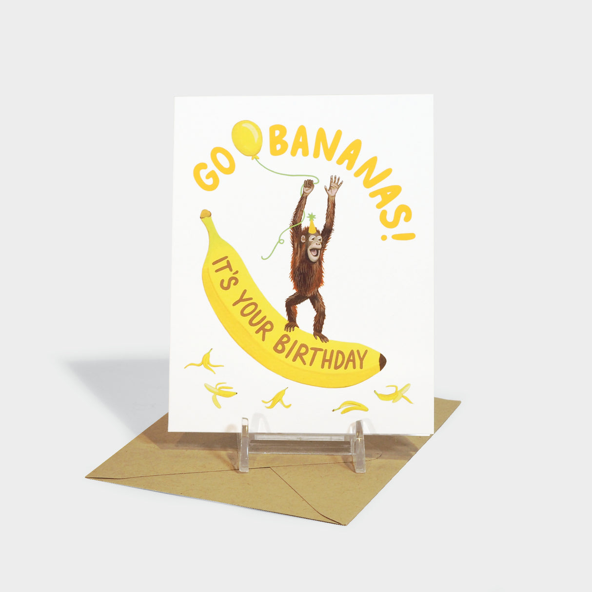 Greeting card with illustration of an orangutan holding a balloon, standing on a banana.