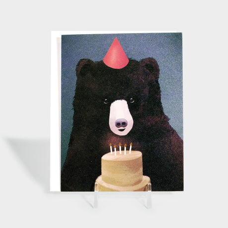 Greeting card featuring an illustration of a bear in a party hat about to blow out candles on a cake. There's no text on the front.