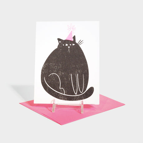 Risograph printed greeting card with large black cat in a party hat. Card does not feature any text.