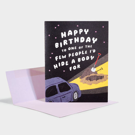 Birthday card with illustration of a car, with headlights illuminating a hole dug in the ground.
